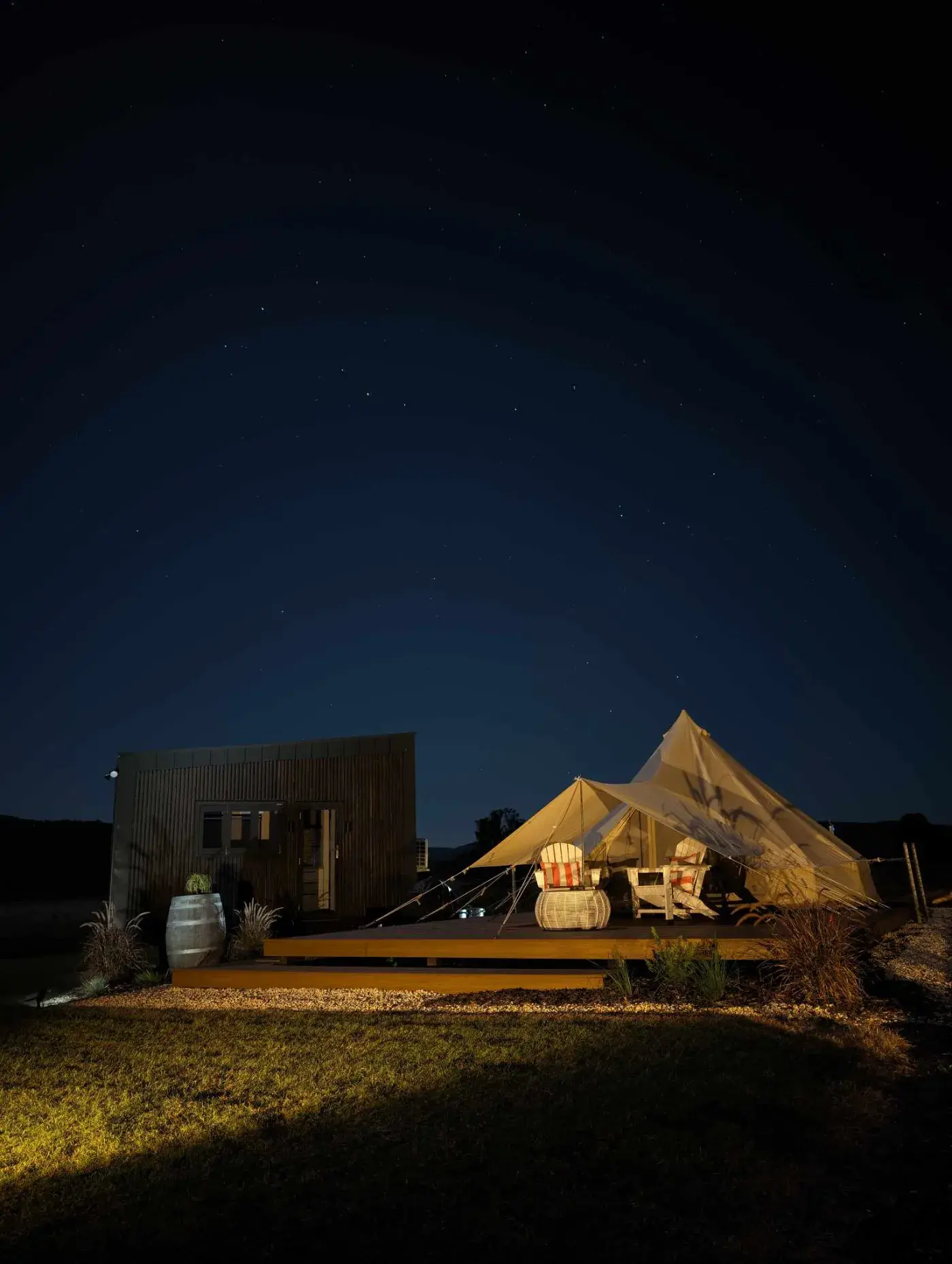 The tent and pod lit from outside at night under a sky full of stars