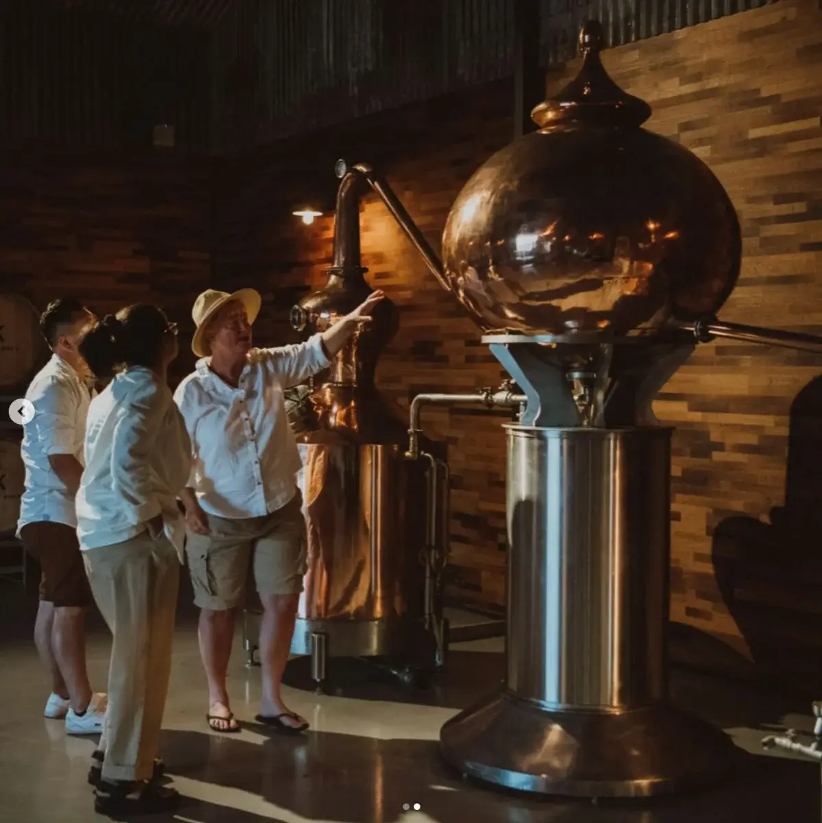Guests beside the copper still at Kawal Rock distillery, Broke