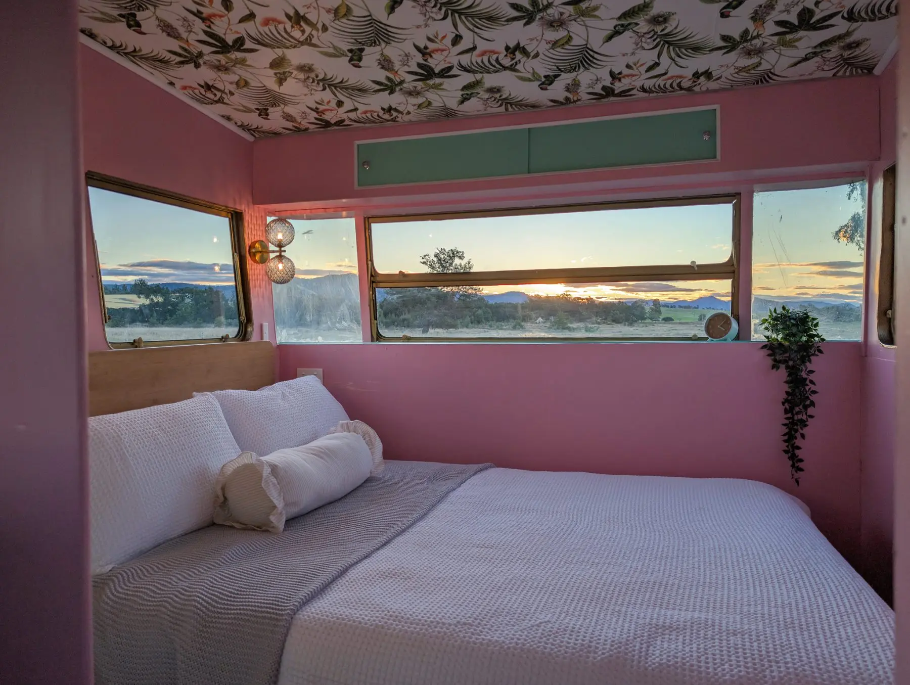 The double bed across the back of the van, sunset through the window